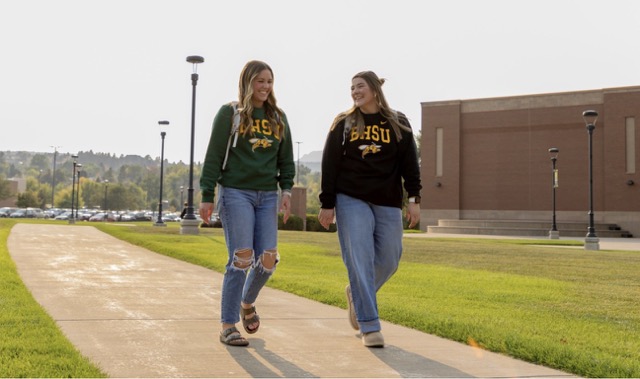 Two female BHSU students walking on campus.