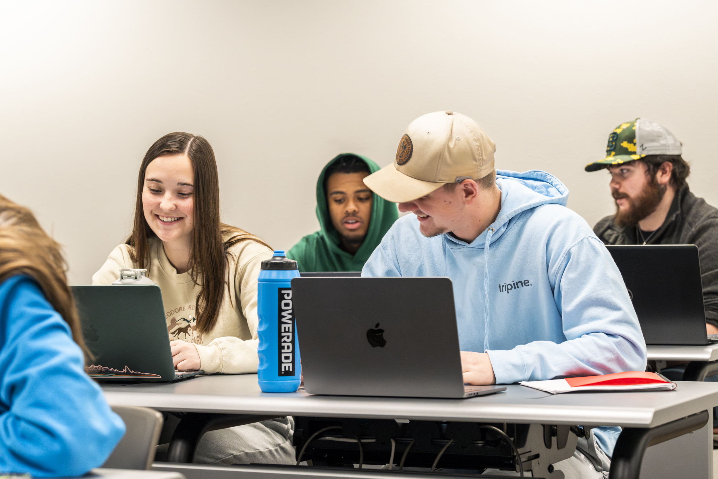 Four BHSU General Studies students sit in a classroom looking at their laptops.