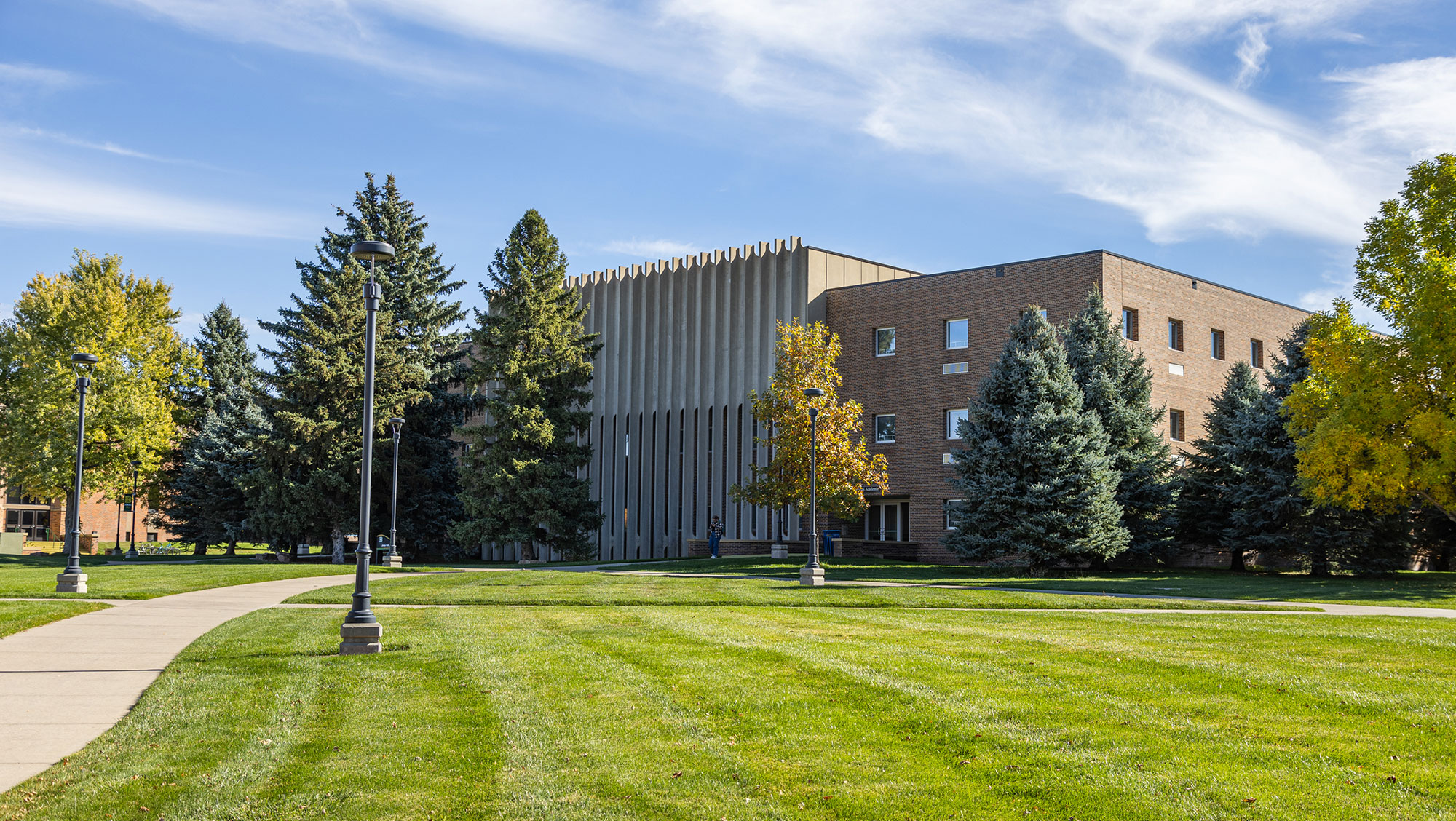 Jonas Hall on sunny day surrounded by green grass and trees.