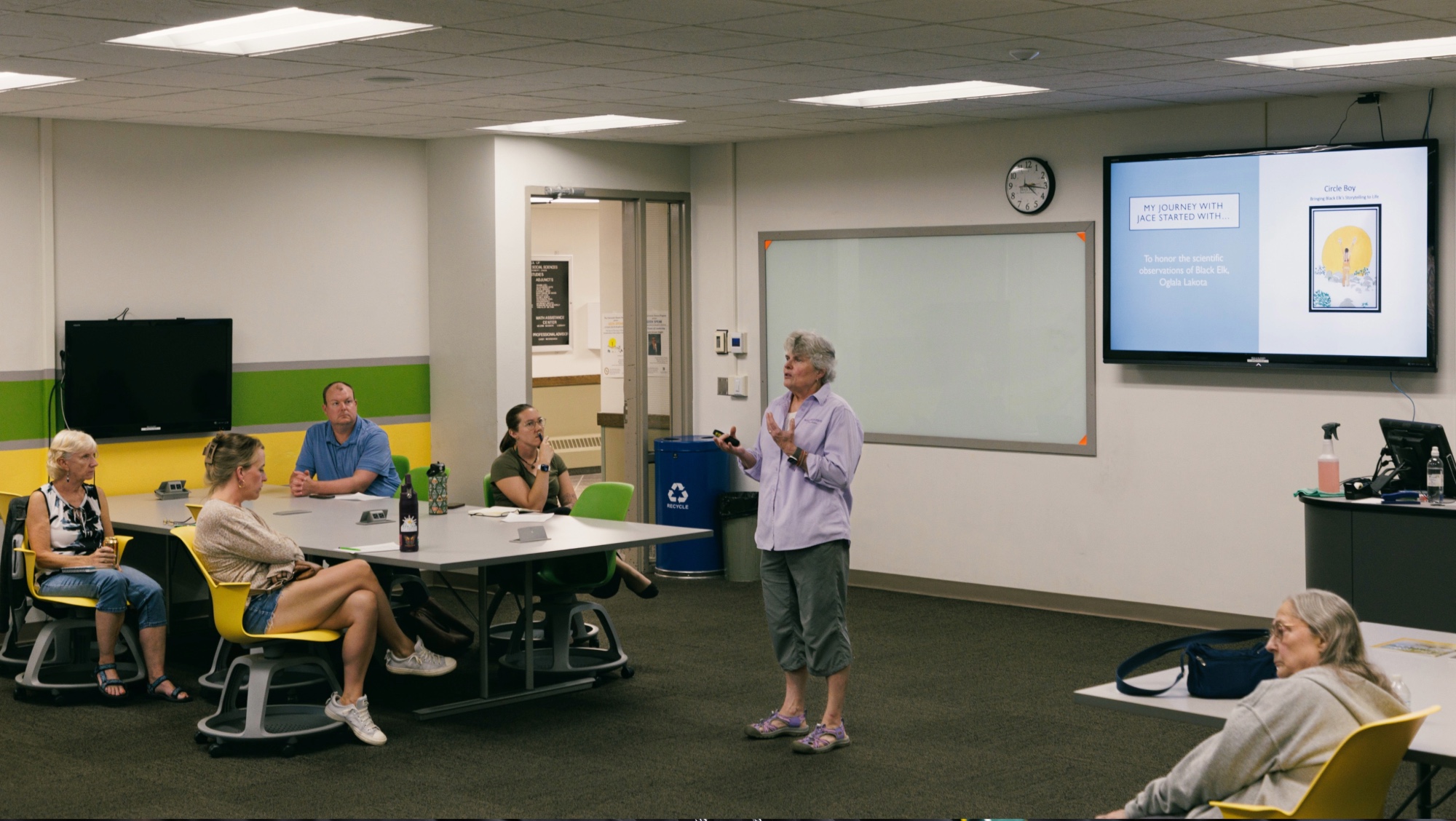 A women speaks to an audience of several people in a Jonas Hall classroom during a Geek Speak presentation